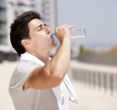 Man drinking water outside