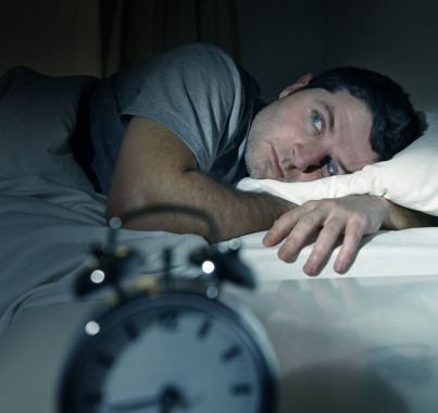 Man in bed trying to sleep